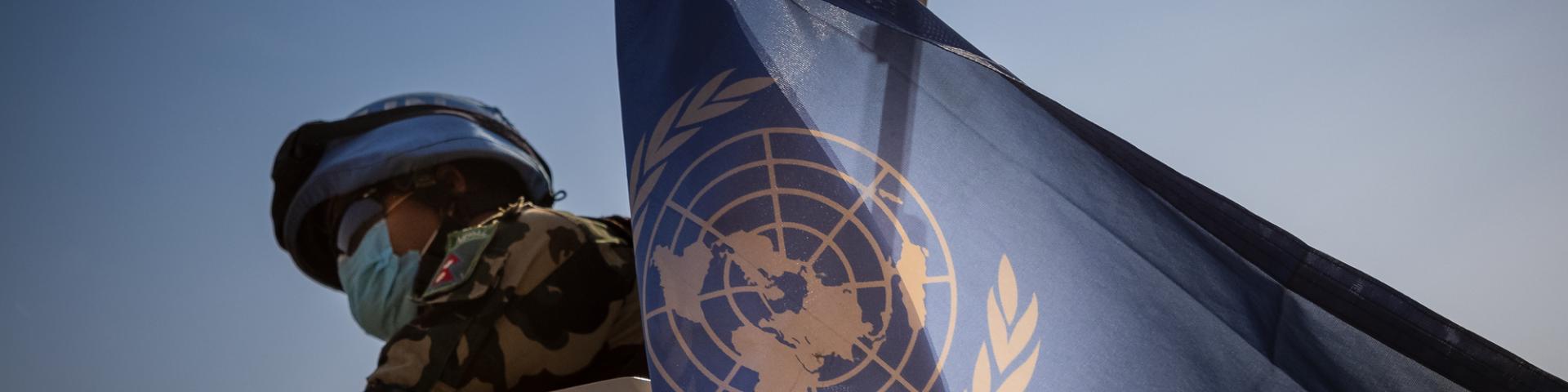 UN Peacekeeper holding a UN flag