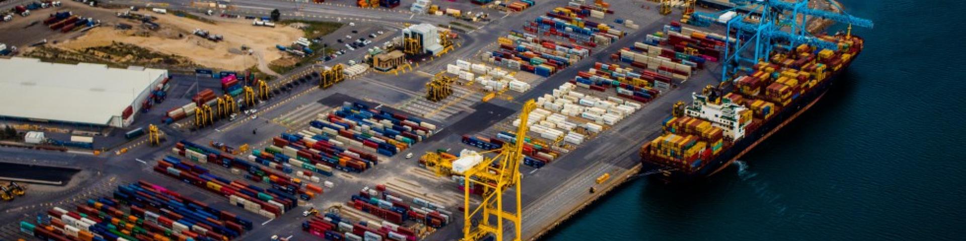 Aerial view of a working container terminal with crane and ship being loaded/